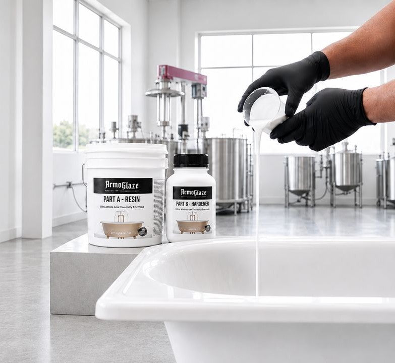 A person wearing black gloves pours liquid from a small bottle into a white tub, with two branded resin containers standing on a pedestal in a bright industrial workshop. The visible product branding reads Armoglaze.